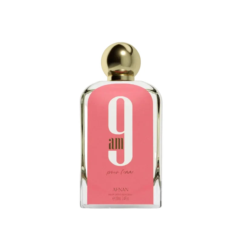 Perfume bottle with pink label and gold cap on a light gray background